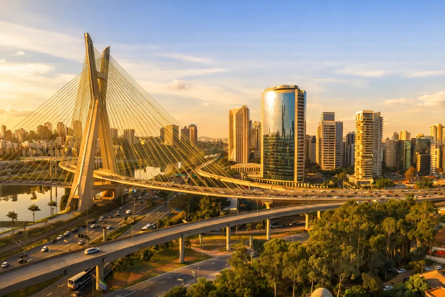 Panoramic view of a cable-stayed bridge and Sao Paulo skyline at sunset with highways in the foreground