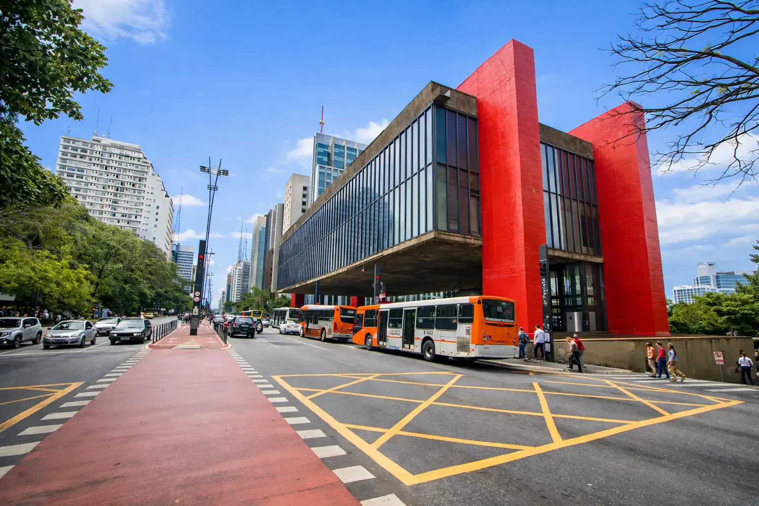 Modern red-columned museum beside Paulista avenue with city buses