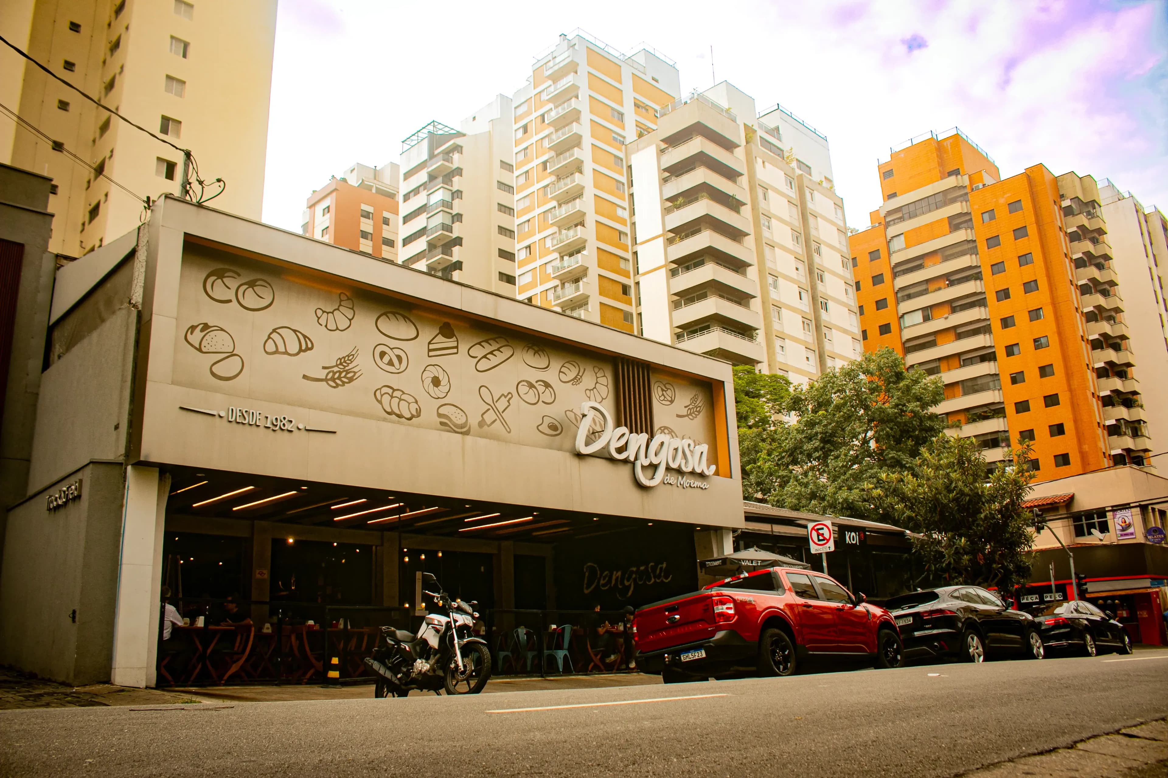 Facade of Cabana restaurant in Moema, with pedestrians and a dog on the sidewalk